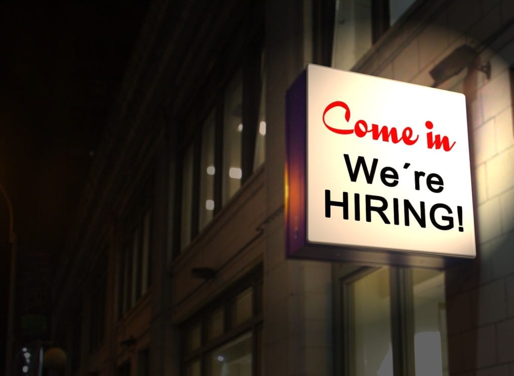 Neon sign on building We're Hiring