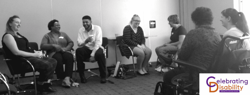 Black and white image of delegates laughing whilst attending a Celebrating Disability training session