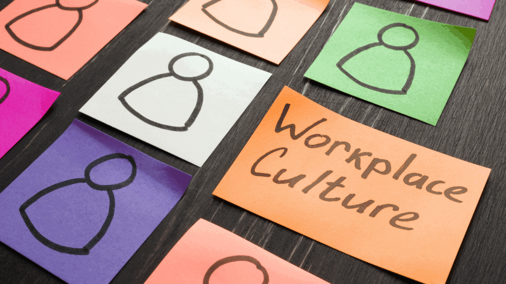 Coloured sticky notes arranged on a desk, each showing a simple outline of a person. One orange note in the centre reads “Workplace Culture,” symbolising an inclusive workplace culture that values diversity and inclusion.